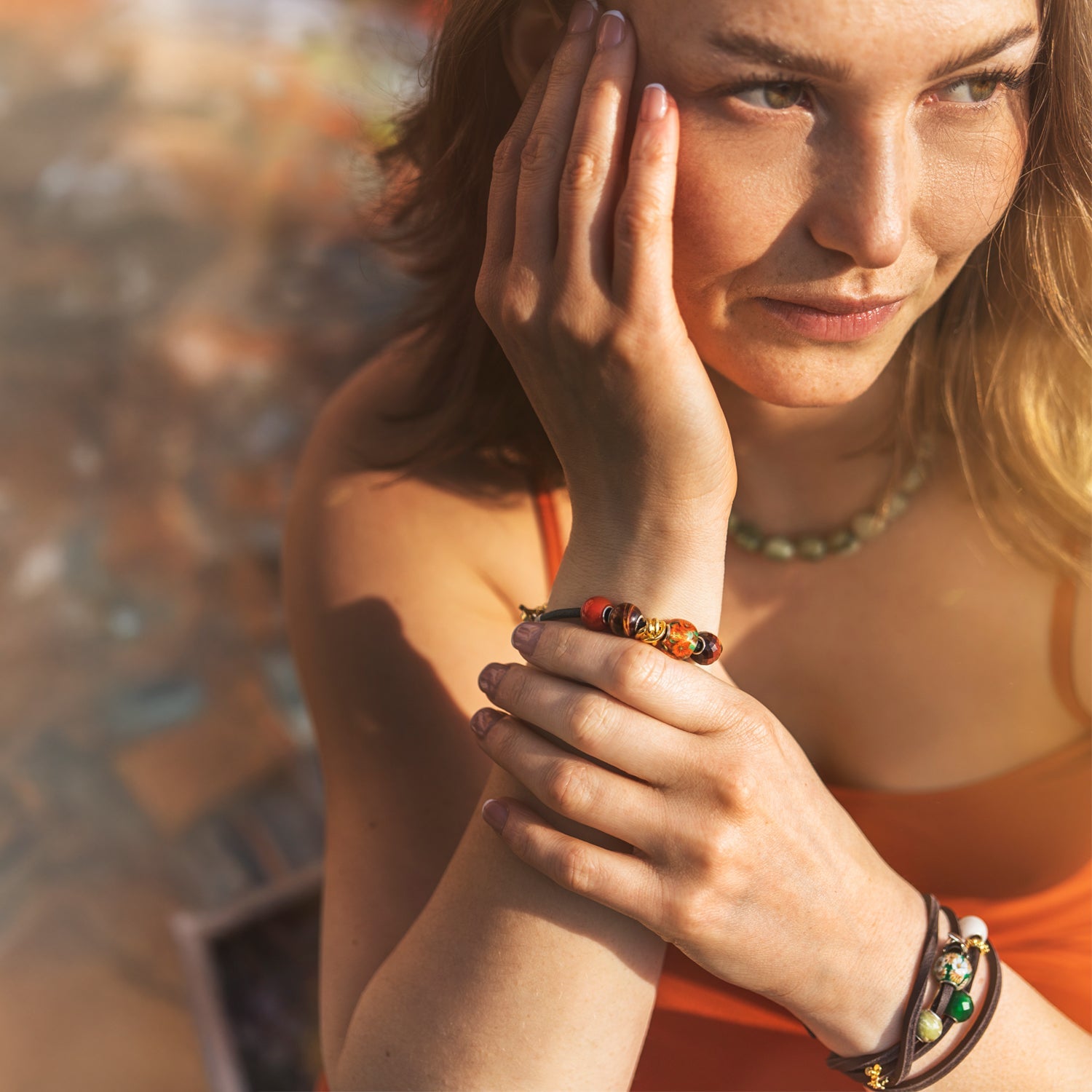 Woman wearing colorful bracelets on a blurred outdoor background